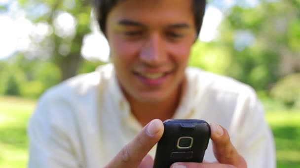 Smiling man typing on his cellphone — Stock Video