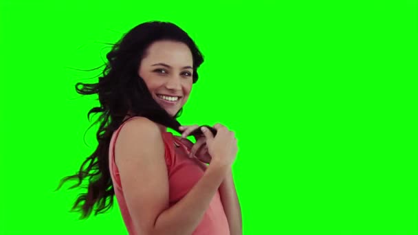 Eine lächelnde Frau spielt mit ihren Haaren — Stockvideo