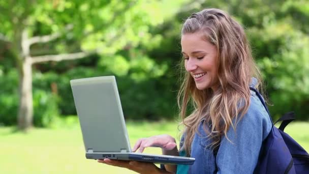 Smiling student holding a laptop — Stock Video