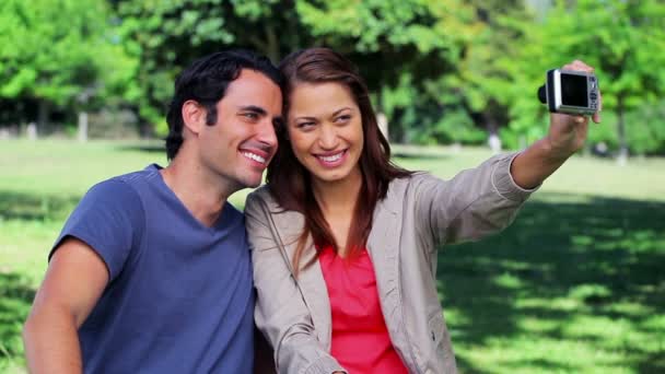 Smiling couple sitting while photographing themselves — Stock Video