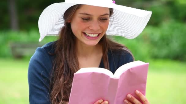 Усміхнена жінка тримає книгу — стокове відео