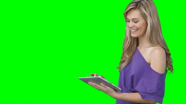 Eine Frau benutzt ihren Tablet-PC, während sie auf den Bildschirm schaut — Stockvideo