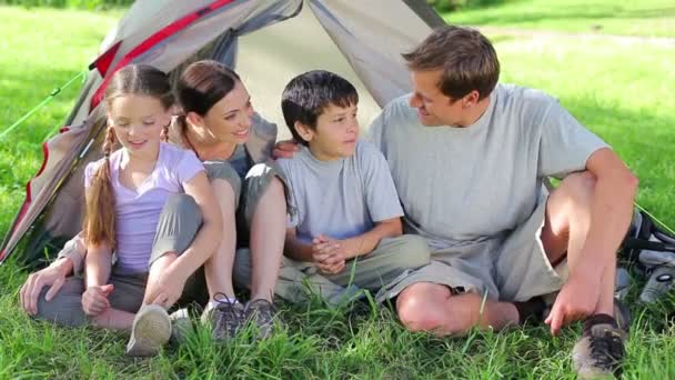 Famille souriante assise sur l'herbe ensemble — Video