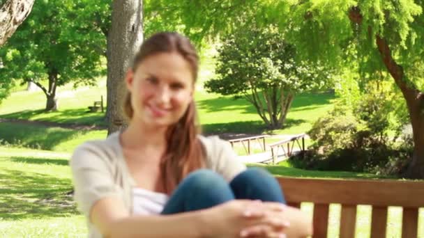 Smiling woman sitting on a bench — Stock Video