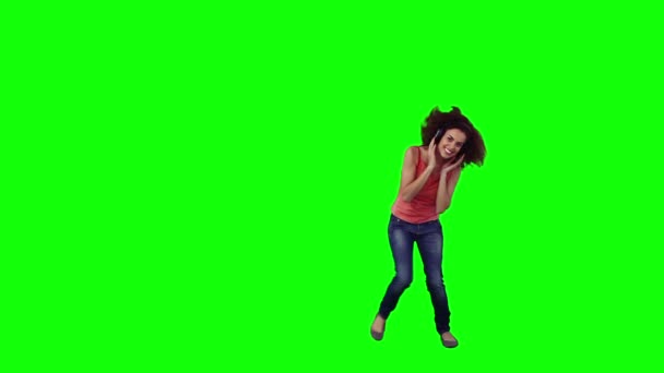 Una mujer saltando lleva auriculares. — Vídeo de stock