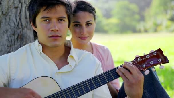 Donna sorridente che ascolta il suo ragazzo che sta suonando la chitarra — Video Stock