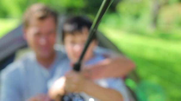 Alegre padre e hijo usando una caña de pescar — Vídeos de Stock