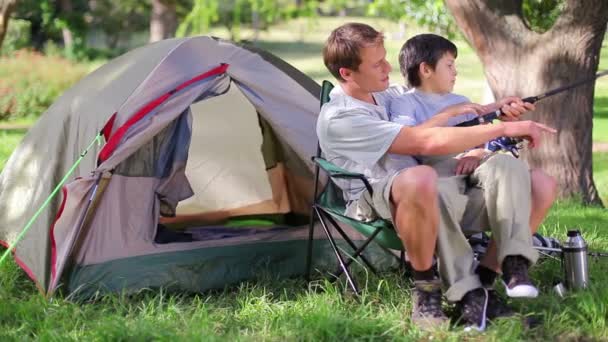 Baba ve oğul kendi çadır yanında otururken balıkçılık — Stok video
