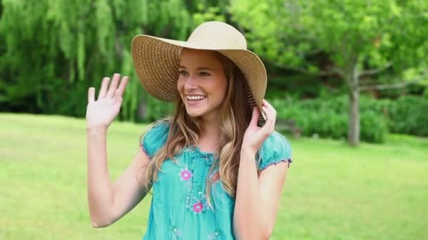 Щаслива жінка тримає солом'яний капелюх — стокове відео