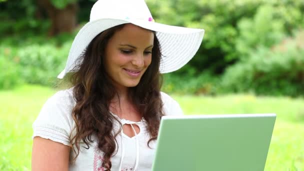 微笑着深色头发的女人用她的笔记本电脑 — 图库视频影像