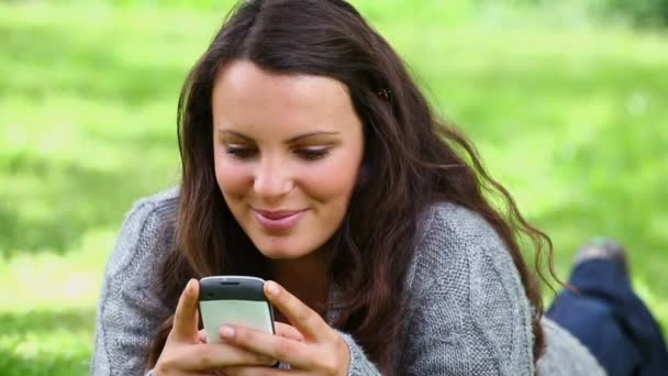 Sorrindo morena mulher enviando uma mensagem de texto — Vídeo de Stock