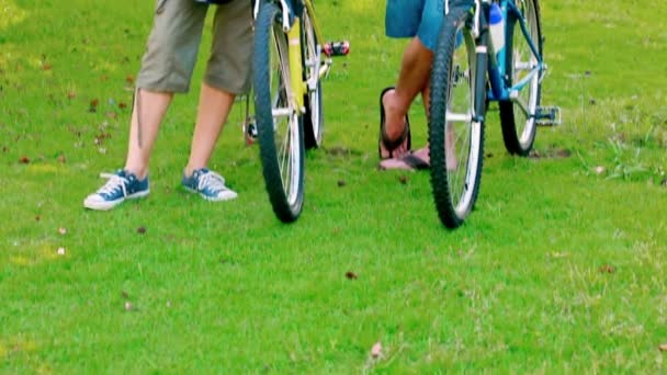 Pareja joven de pie con bicicletas — Vídeos de Stock