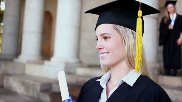 Sonriente estudiante rubia sosteniendo su diploma — Vídeos de Stock