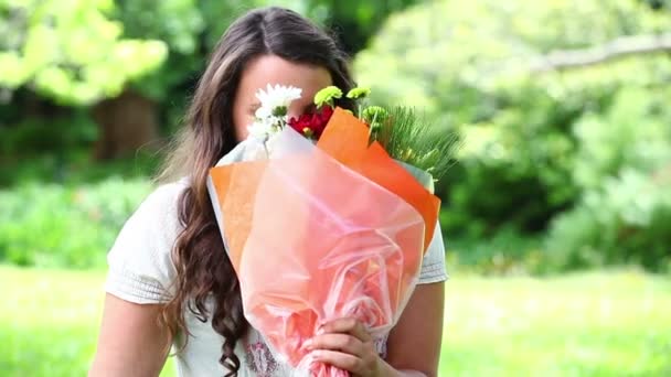 Lächelnde Brünette mit einem Blumenstrauß — Stockvideo