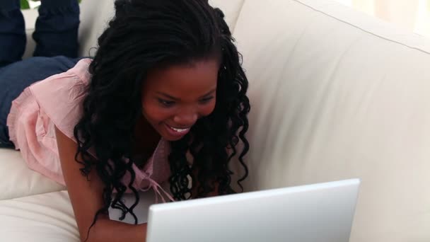 Smiling brunette typing on her laptop — Stock Video