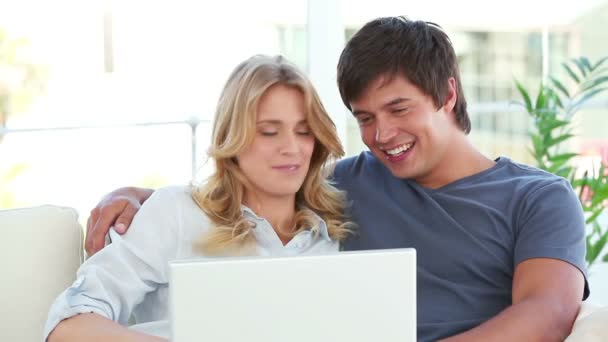 Счастливая пара разговаривает перед ноутбуком — стоковое видео