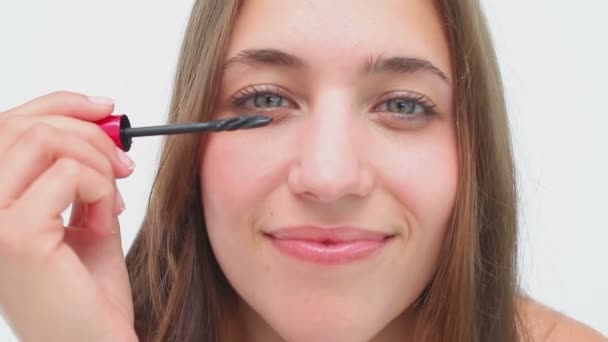 Joyful brunette applying mascara on her eyelashes — Stock Video