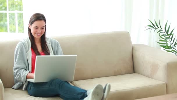 Mujer morena sonriente usando su computadora personal — Vídeo de stock