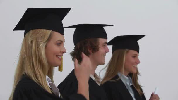 Sonrientes amigos siendo graduados juntos — Vídeos de Stock