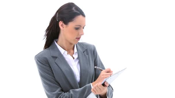 Brunette businesswoman writing on a clipboard — Stock Video