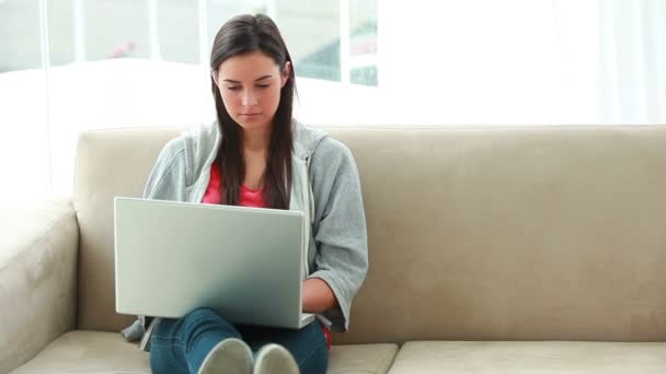 Ernstige brunette vrouw met behulp van een laptop — Stockvideo