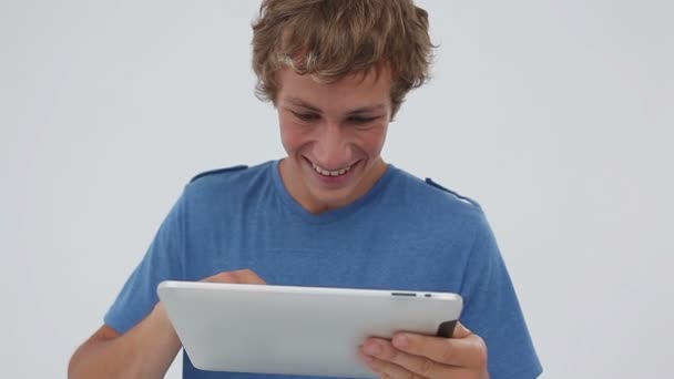 Χαμογελαστός νεαρός χρησιμοποιώντας έναν υπολογιστή δισκίο — Αρχείο Βίντεο