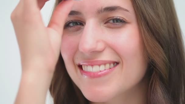 Happy woman using a pair of tweezers — Stock Video