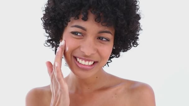 Primer plano de una mujer que se aplica crema en la cara — Vídeo de stock