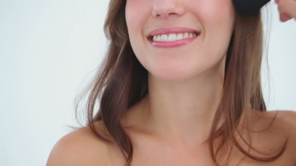 Усміхнена жінка наносить основу на обличчя — стокове відео