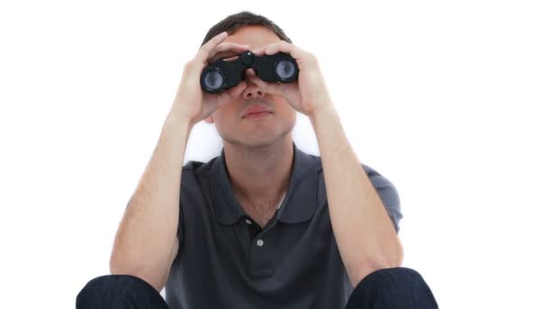 A sitting man is looking through binoculars — Stockvideo