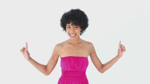 Mujer sonriente en rosa señalando hacia arriba — Vídeos de Stock