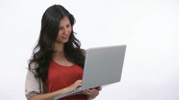 Woman using a laptop while holding it — Stock Video