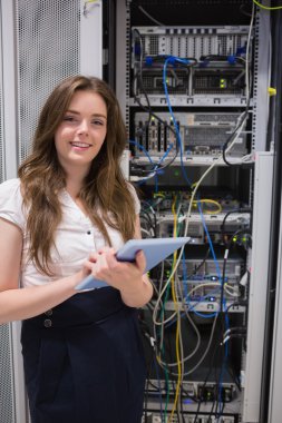 Smiling woman using tablet pc to work on servers clipart