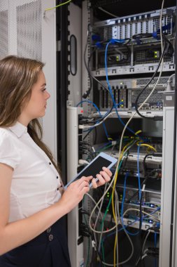 Woman with tablet pc looking at the servers clipart