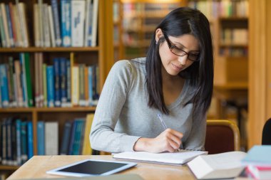 Woman studying in the library clipart