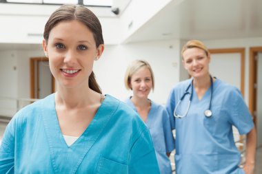 Smiling nurse with two friends clipart