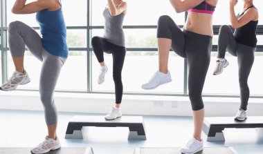 Women raising their legs while doing aerobics clipart