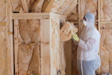 Worker filling walls with insulation material clipart