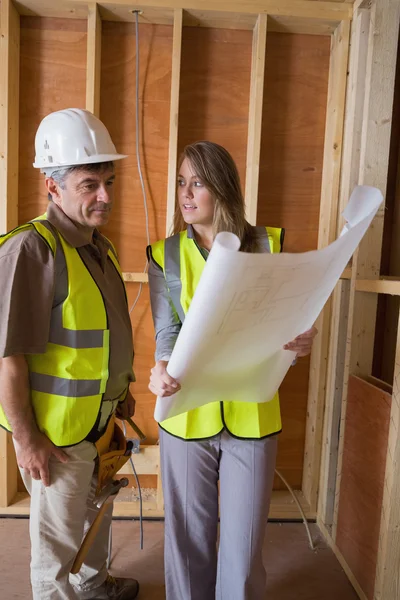 Woman and man discussing blueprints — Stock Photo, Image