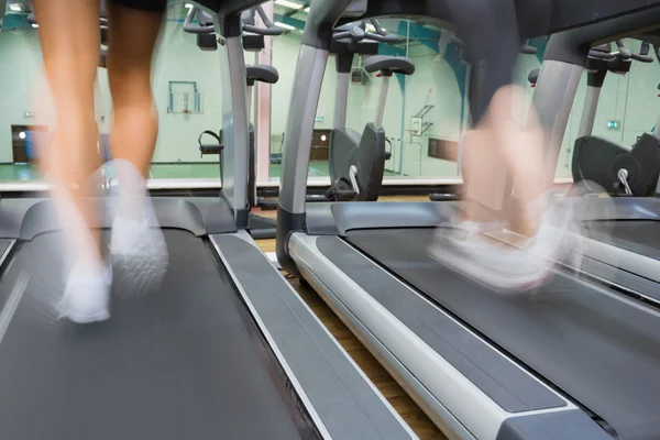 Courir sur un tapis roulant dans la salle de gym — Photo