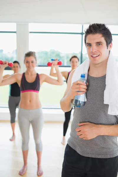 Mann steht im Fitnessstudio und hält eine Flasche Wasser — Stockfoto