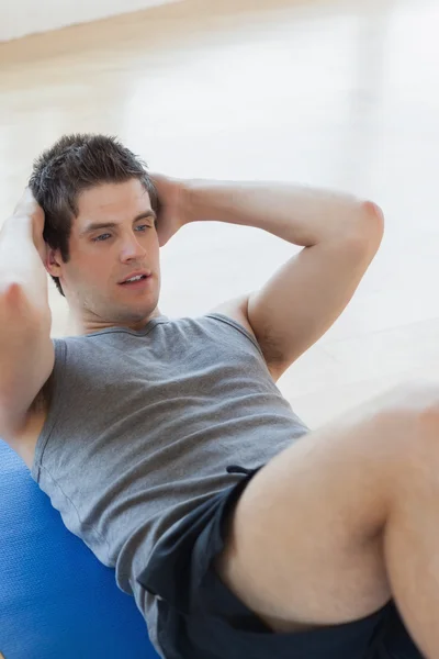 Hombre haciendo sentadas en el gimnasio — Foto de Stock