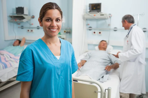 Felice infermiera in piedi in camera d'ospedale — Foto Stock
