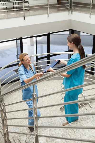 Медсестра передає теку до іншої медсестри — стокове фото