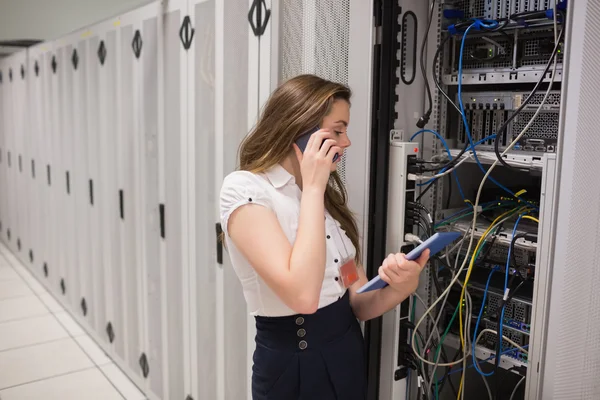 Femme sur le téléphone tenant tablette pc vérifier les serveurs — Photo