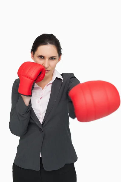Serious brunette wearing red gloves while punching — Stock Photo, Image