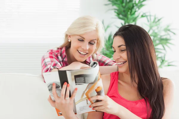 Mulheres olhando para o catálogo sorrindo — Fotografia de Stock