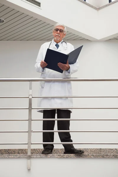 Doctor parado en la barandilla mirando — Foto de Stock