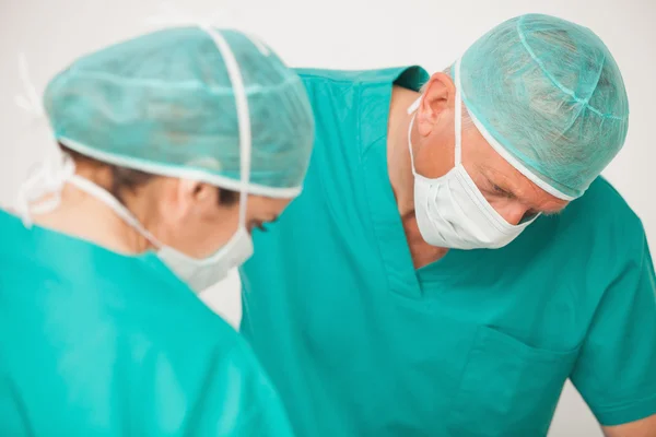 Two surgeons looking down on patient — Stock Photo, Image