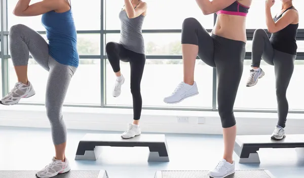 Las mujeres levantando las piernas mientras hacen aeróbicos — Foto de Stock